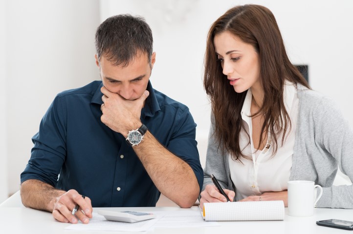 Portrait Of A Worried Couple Calculating Financial Budget